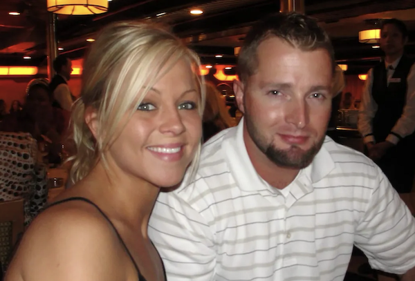 A friendly pair, seated indoors at a busy eatery, take a close-up snapshot amid a softly glowing ambiance.