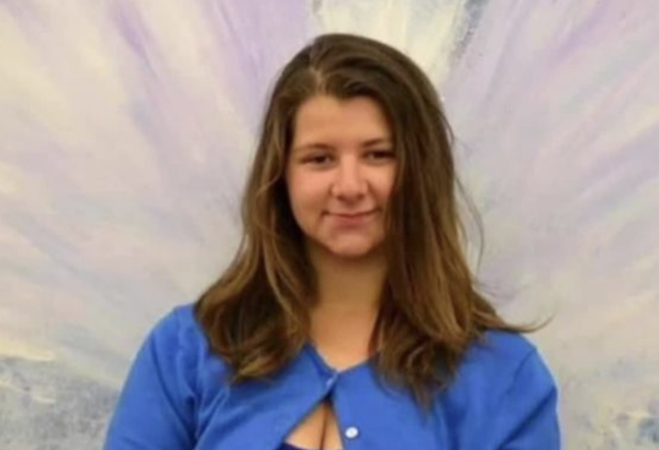 Portrait of a woman with relaxed hair and casual blue attire, centered amid an artistic backdrop with light, feathery strokes.