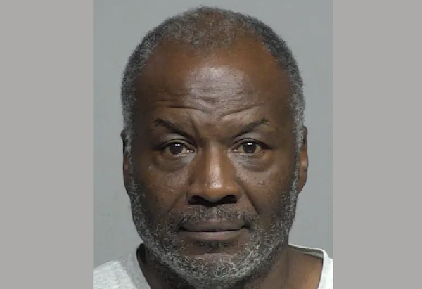 Head-and-shoulders image of an African American man with a trimmed beard, wearing a crewneck shirt, shown in front of a smooth, gray background.