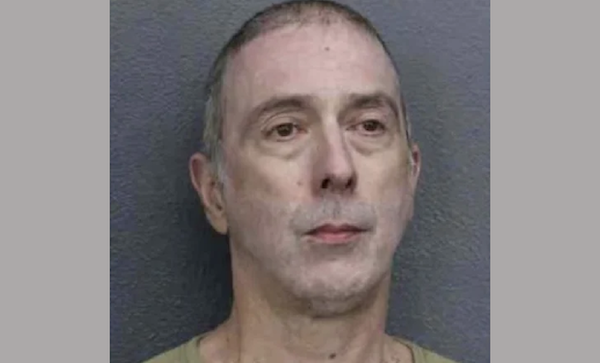 Booking photograph of a middle-aged man facing forward, with short graying hair and a subdued expression.