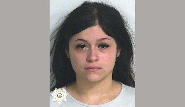 Head-and-shoulders portrait of a young woman with straight dark hair, photographed front-facing in a booking photo.